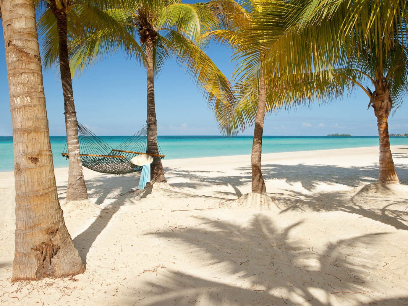 Hotels outdoor Beach water sky tree palm shore body of water Sea Ocean vacation caribbean sandy Nature sand arecales plant Coast tropics bay shade