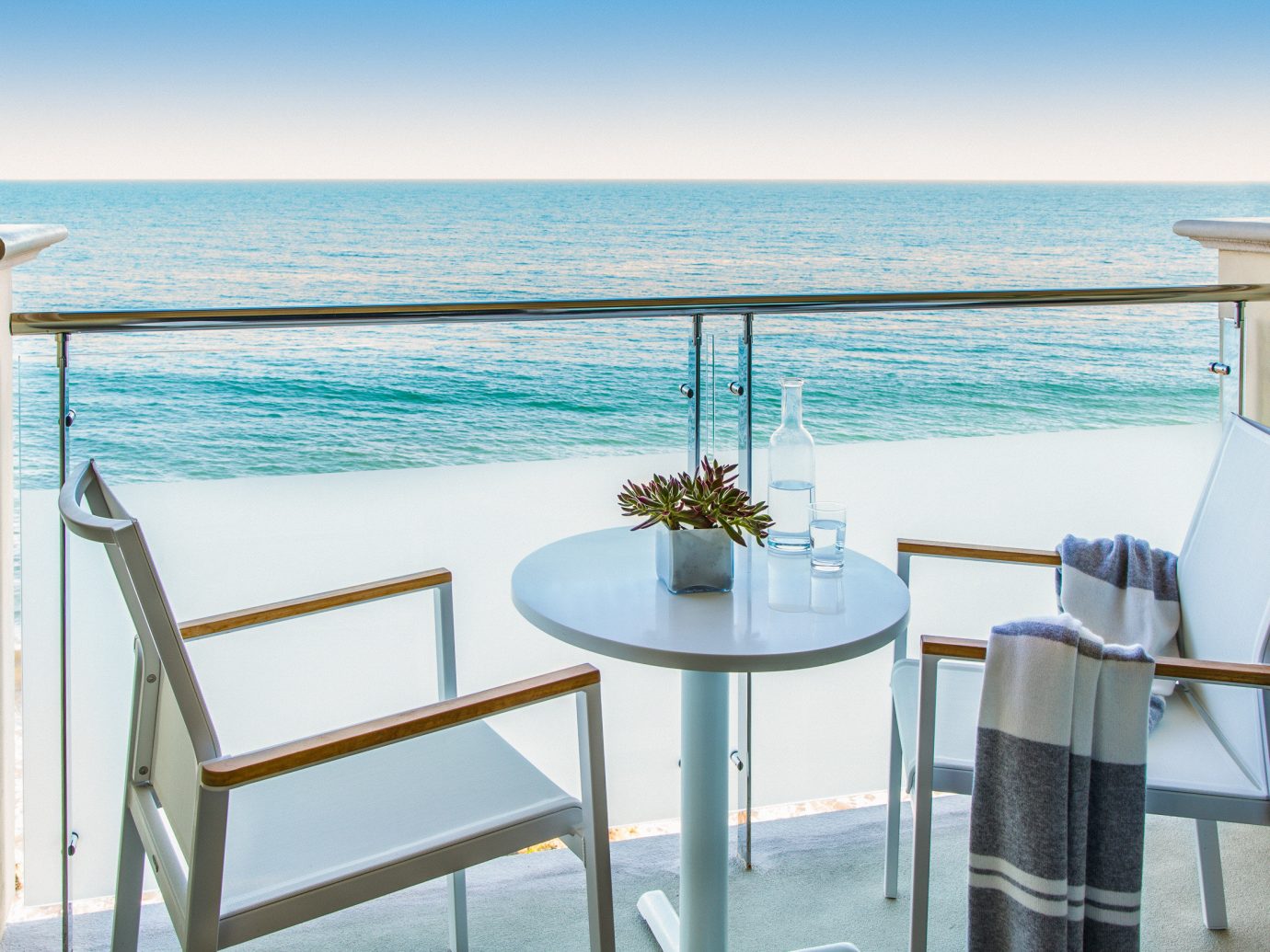 Arts + Culture Hotels Jetsetter Guides shopping Travel Trends Trip Ideas water sky chair body of water Sea outdoor table Ocean vacation furniture real estate Balcony overlooking shore Beach house Deck