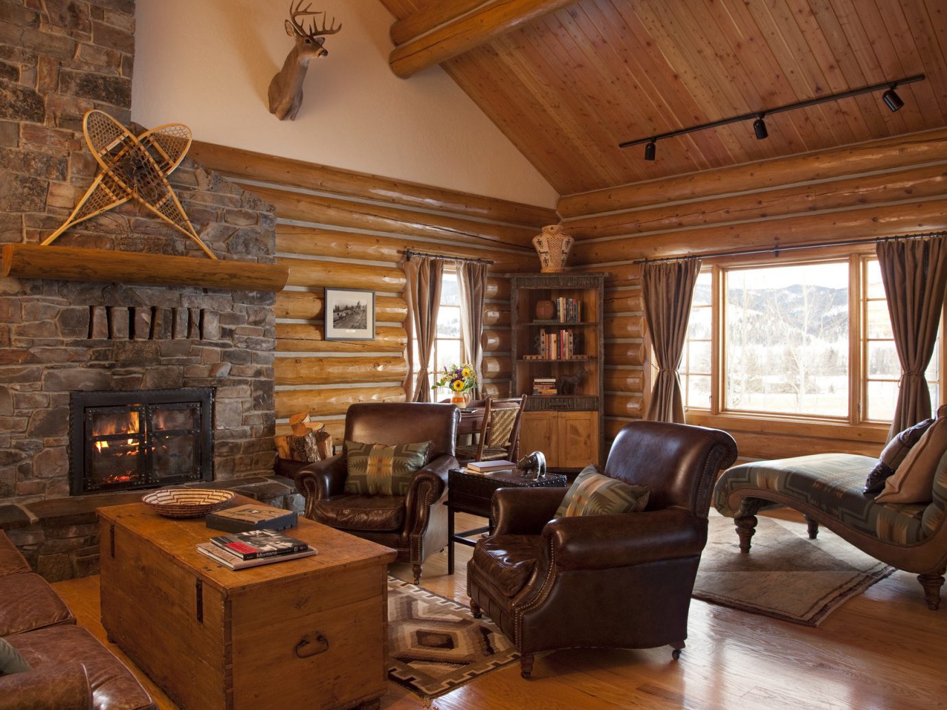 Glamping Hotels Montana Outdoors + Adventure Trip Ideas indoor Living room floor Fireplace property window living room estate home fire log cabin house furniture cottage hardwood ceiling wood farmhouse interior design real estate wood flooring stone
