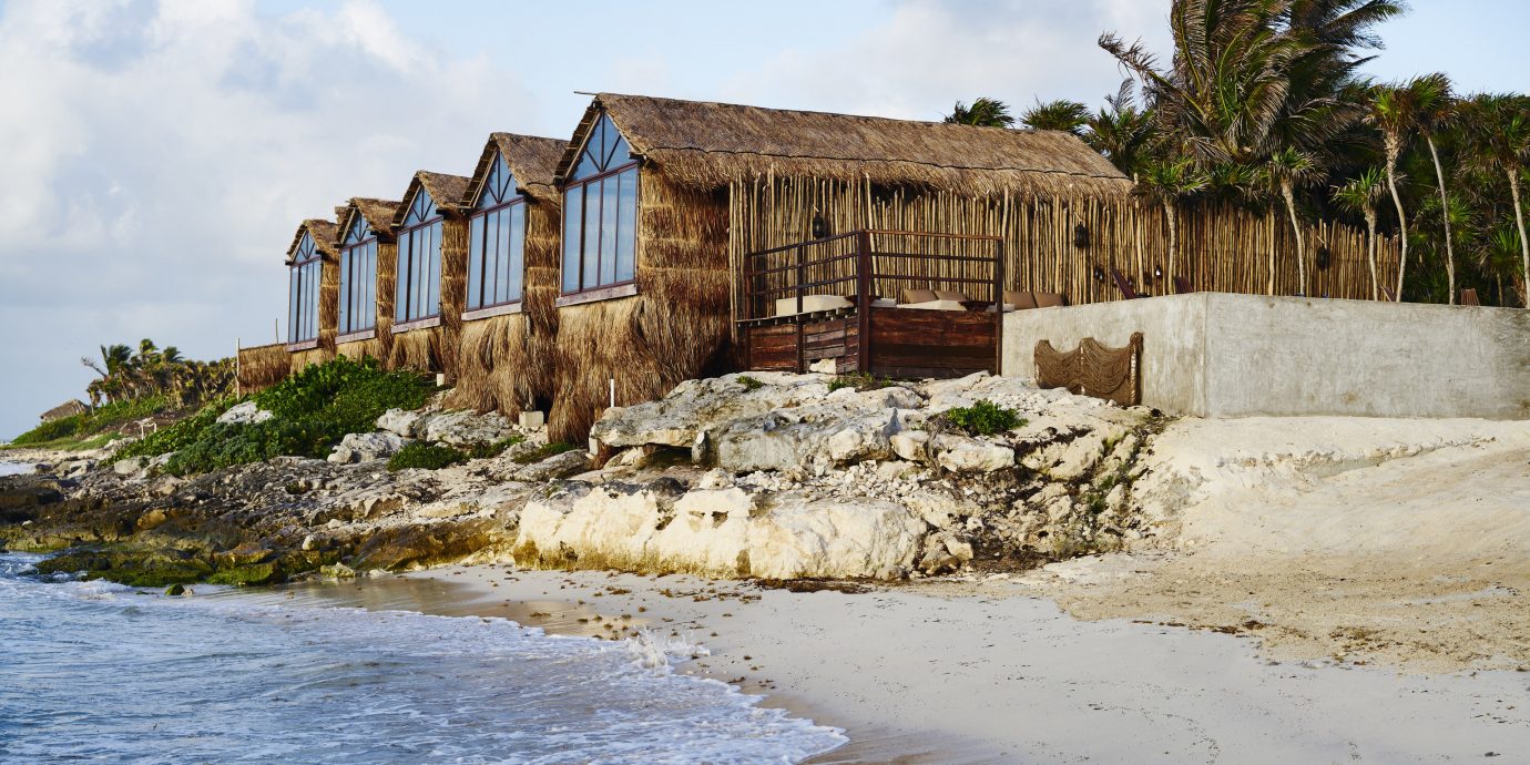 Boutique Hotels Hotels Mexico Tulum sky outdoor body of water house Coast water shore Sea wood Nature real estate cottage Ocean old shack tree rock stone