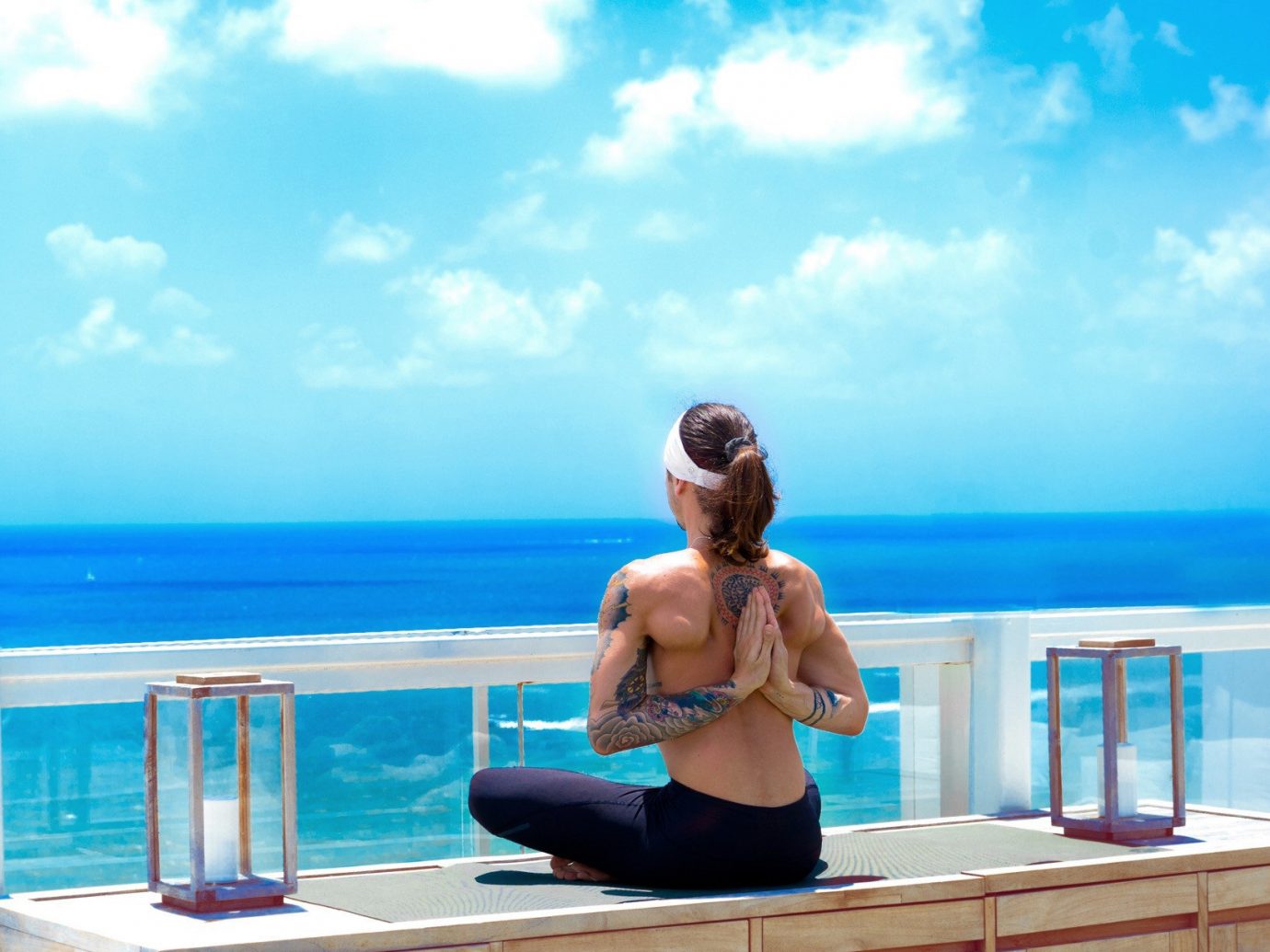 Health + Wellness Hotels Yoga Retreats sky outdoor human action leisure human positions sitting blue swimming pool vacation physical fitness sun tanning leg Sea sports shore