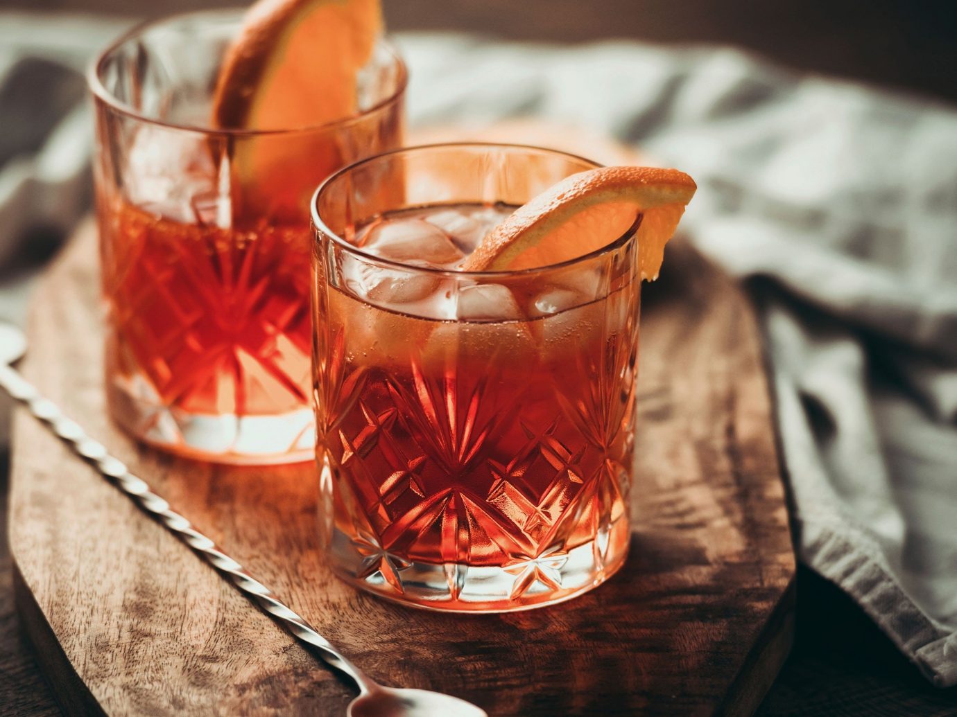 Food + Drink table cup sitting indoor Drink glass alcoholic beverage distilled beverage slice whisky negroni old fashioned container beverage alcohol close meal sliced