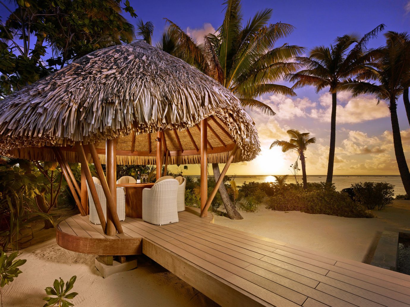 Beach Dining golden hour Hotels isolation majestic Ocean outdoor dining private private dining remote Romance Romantic serene Sunset Tropical white sands tree Resort vacation estate arecales Villa plant palm hut furniture decorated