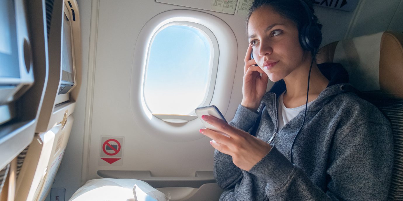 Girl listening to a phone on a plane