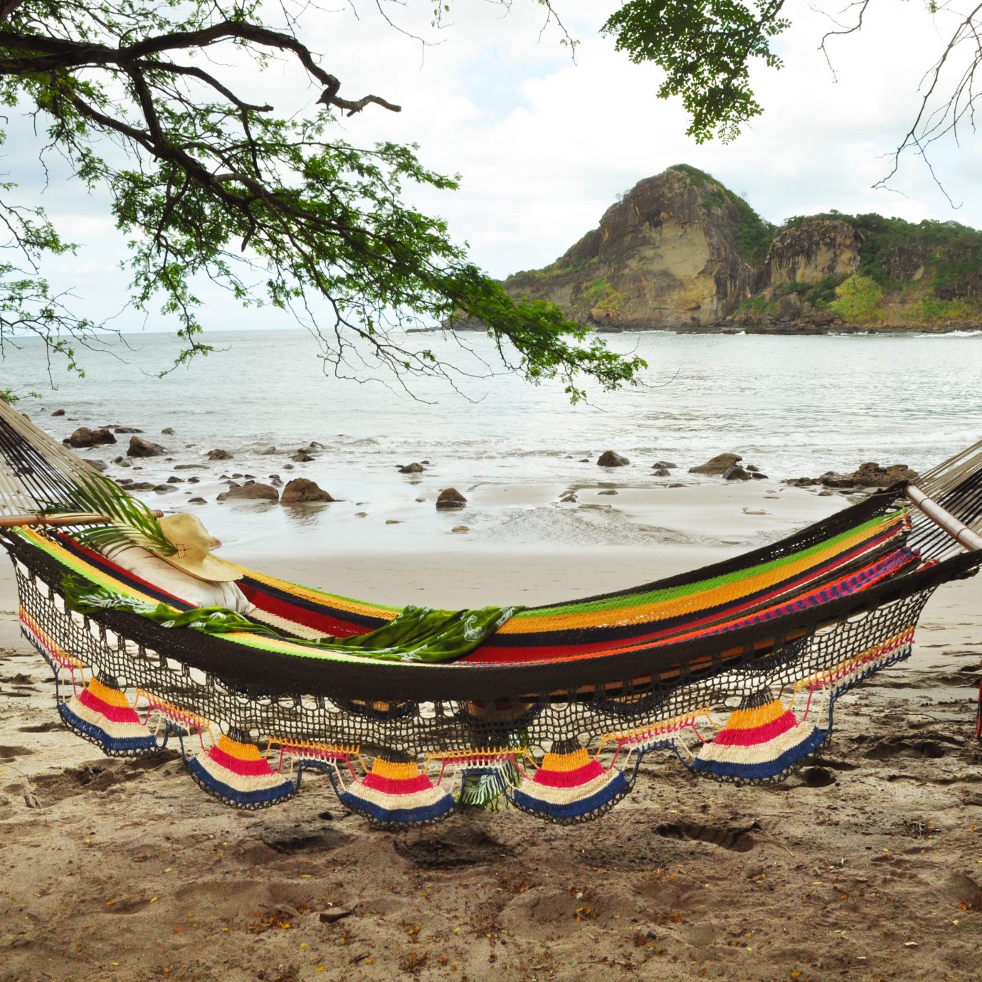 Beach Beachfront Mountains Outdoors Resort Scenic views tree water sky ground hammock long tail boat watercraft rowing Boat boating vehicle sand line shore sandy