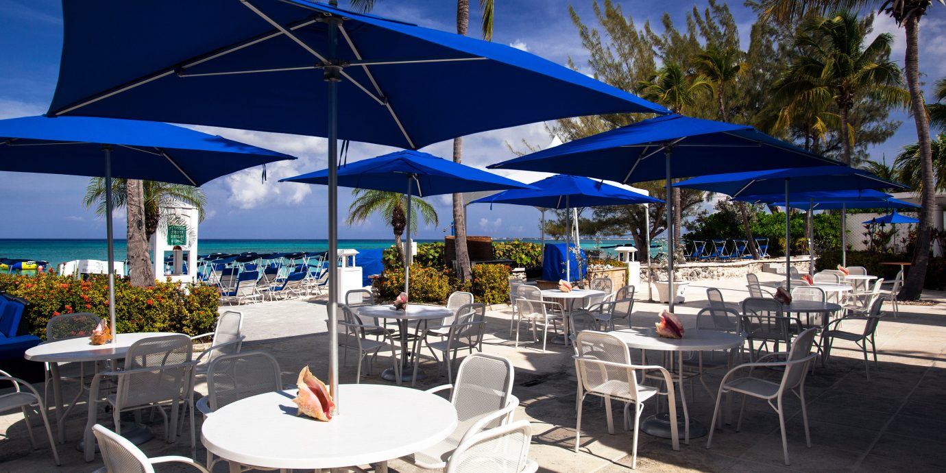 Beach Deck Dining Drink Eat Modern Outdoors tree umbrella chair restaurant Resort vehicle caribbean lawn marina blue set shade day