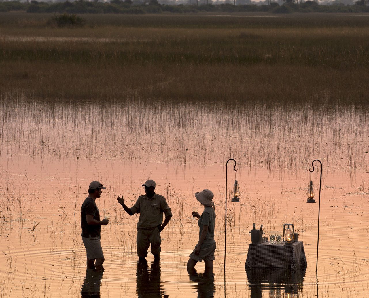 calm fisherman fishing golden hour grass Lake Luxury Nature Outdoor Activities outdoor dining Outdoors people reflection remote River Safari serene silhouette sunrise Sunset Trip Ideas outdoor atmospheric phenomenon natural environment morning dawn wetland evening