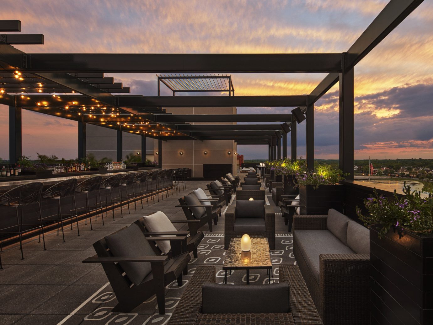 ambient lighting bar seating calm dawn dusk Elegant golden hour Hotels lights lounge chairs Luxury majestic night lights orange sky outdoor lounge regal remote Rooftop serene Solo Travel sophisticated Sunset view sky outdoor bridge lighting evening estate interior design