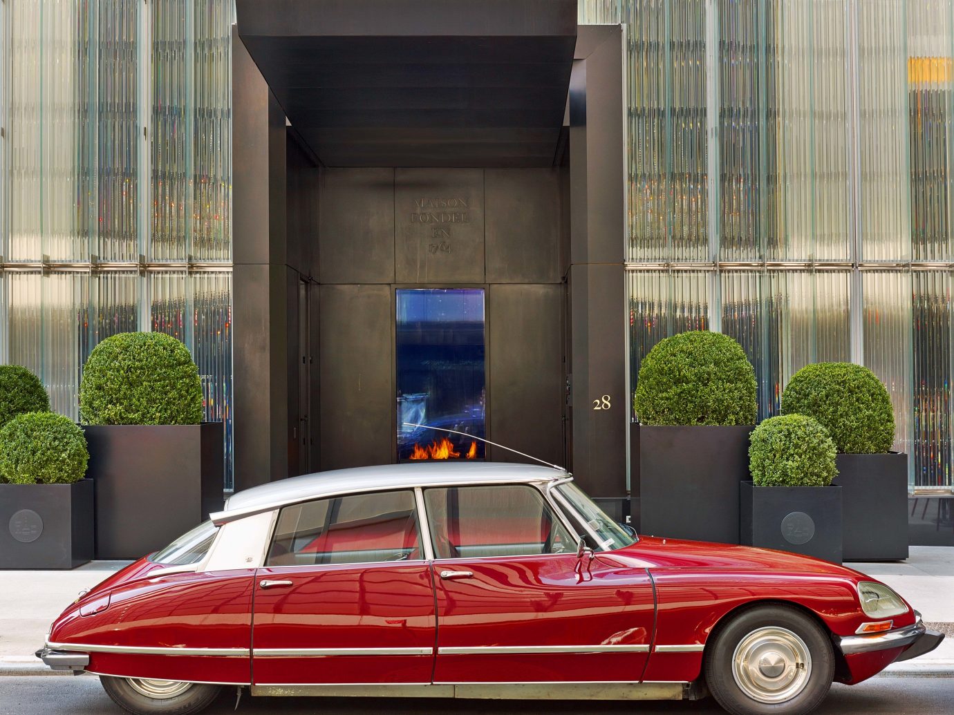 Baccarat Hotel & Residences, Best Hotels in NYC, Offbeat building outdoor car vehicle land vehicle red luxury vehicle automotive design automobile make automotive exterior parked sedan performance car antique car Classic vintage car curb