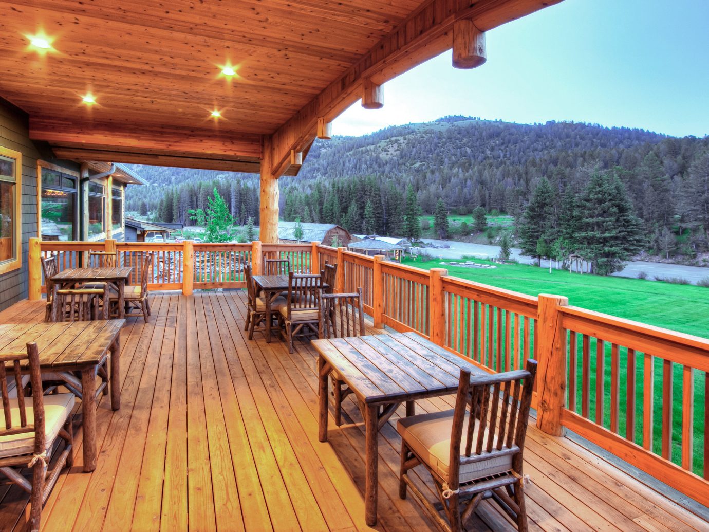Country Deck Glamping Hotels Lodge Montana Outdoors + Adventure Patio Ranch Rustic Scenic views Trip Ideas wooden chair outdoor building property estate Resort cottage real estate outdoor structure Villa porch log cabin eco hotel wood area furniture