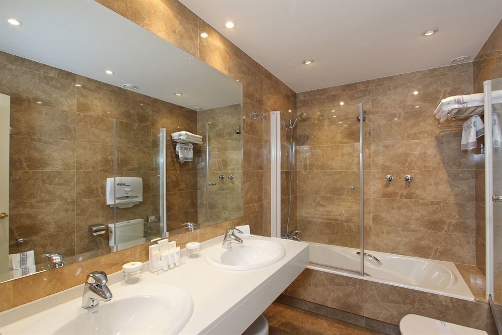 bathroom sink mirror property toilet plumbing fixture bathtub Suite flooring counter tan