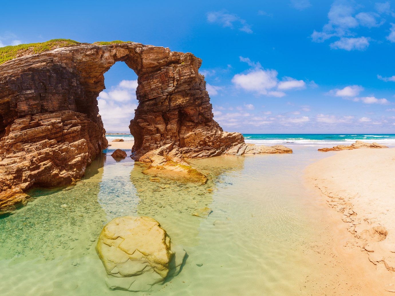 Nature body of water outdoor Sea rock sky Coast coastal and oceanic landforms formation shore natural arch Beach terrain water Ocean vacation sand promontory cliff tourism