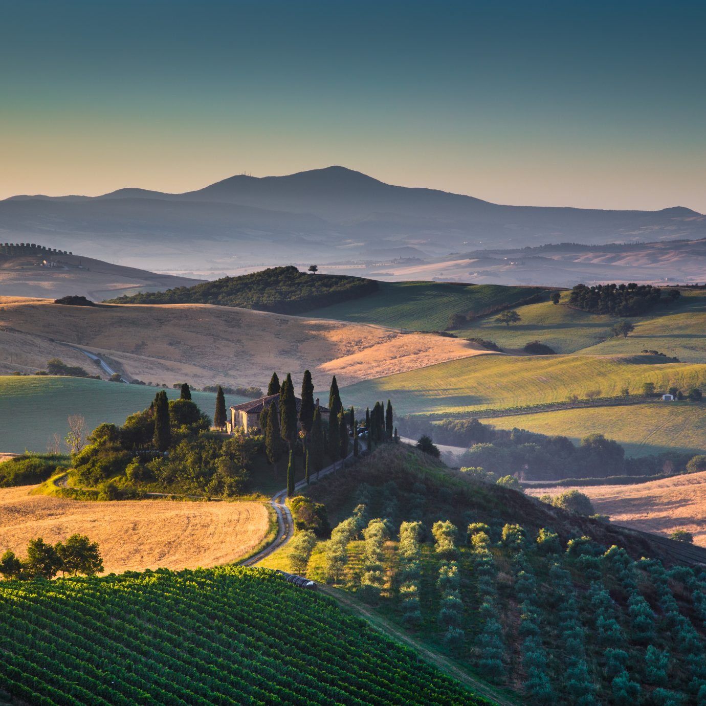 Scenic Tuscany landscape with rolling hills and valleys in golden morning light, Val d'Orcia, Italy.