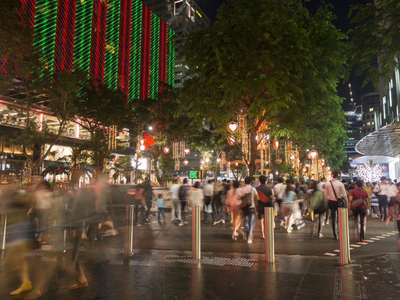 "Shoppers, tourists, walking on the pedestrian crossing in the night after a rain, enjoying the view of Christmas light up along Orchard Road. Singapore Shopping Centres, hotels and the street are light up for Christmas during this festive season."