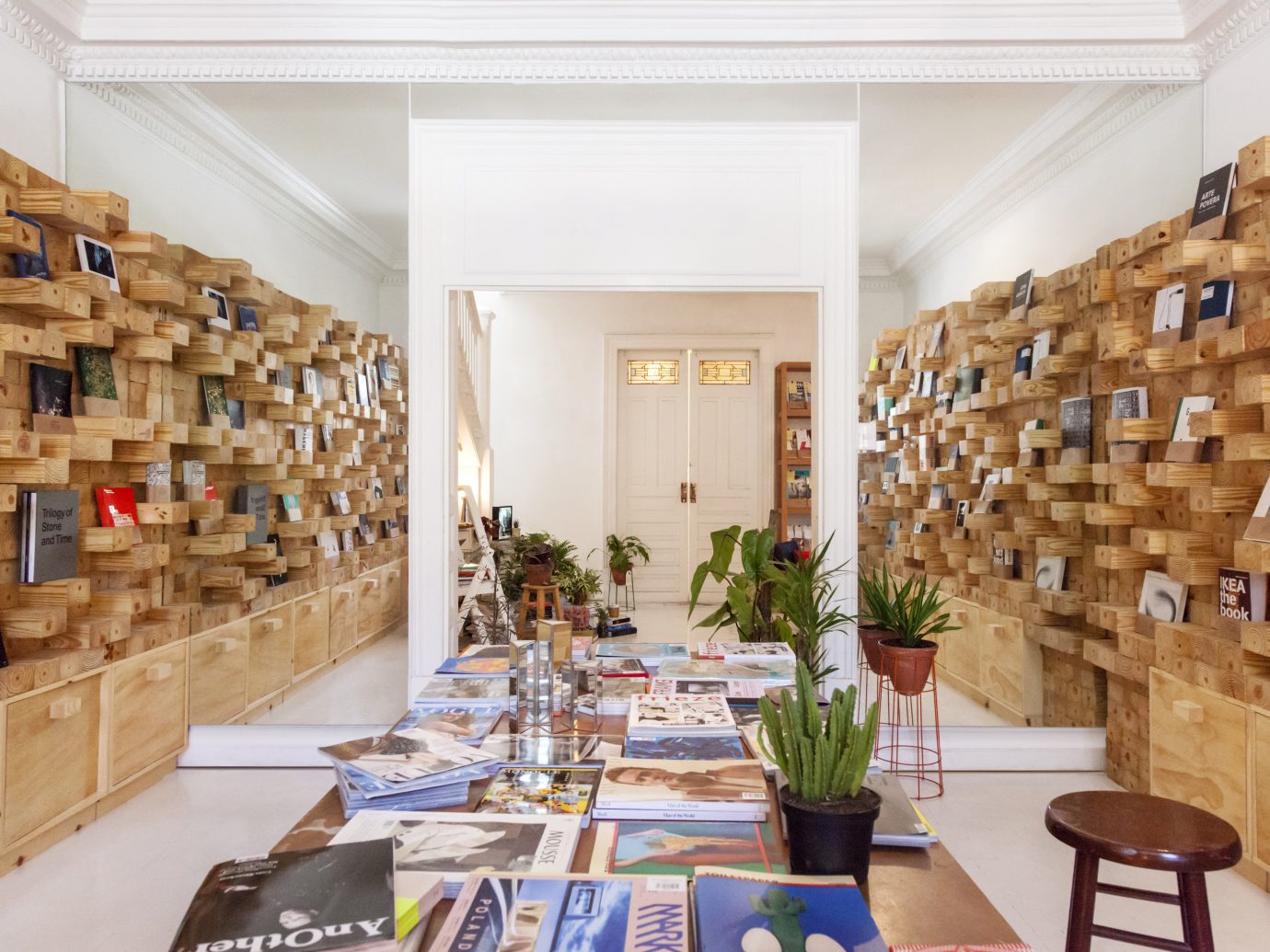 Interior of Casa Bosques in Mexico City with a table full of books and shelves on either sides of the walls