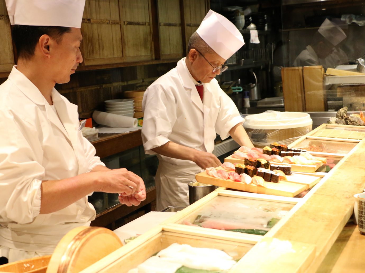 Sushi chefs preparing Sushi plate at small restaurant in Tsukiji Fish Market