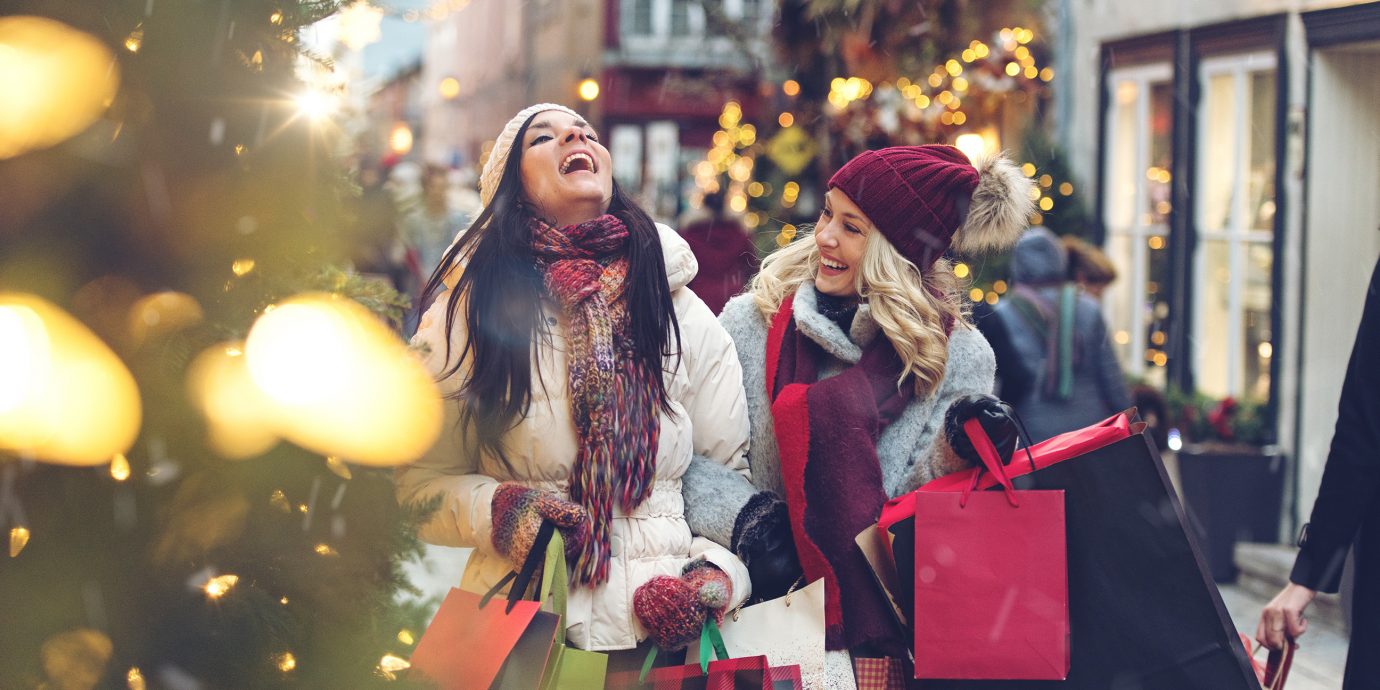 Two women holiday shopping with snow flurries