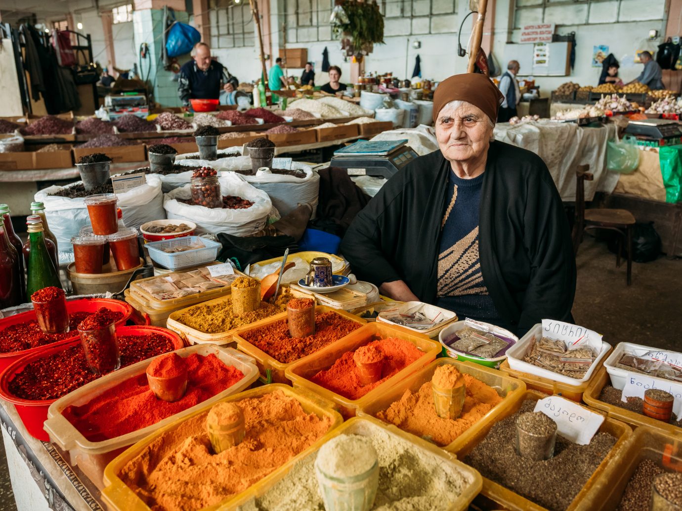 Batumi, Georgia - May 28, 2016: The Elderly Georgian Woman, The Seller Of Aromatic Varicolored Spices Is Waiting For The Buyers At The Counter Of Covered Market Bazar.