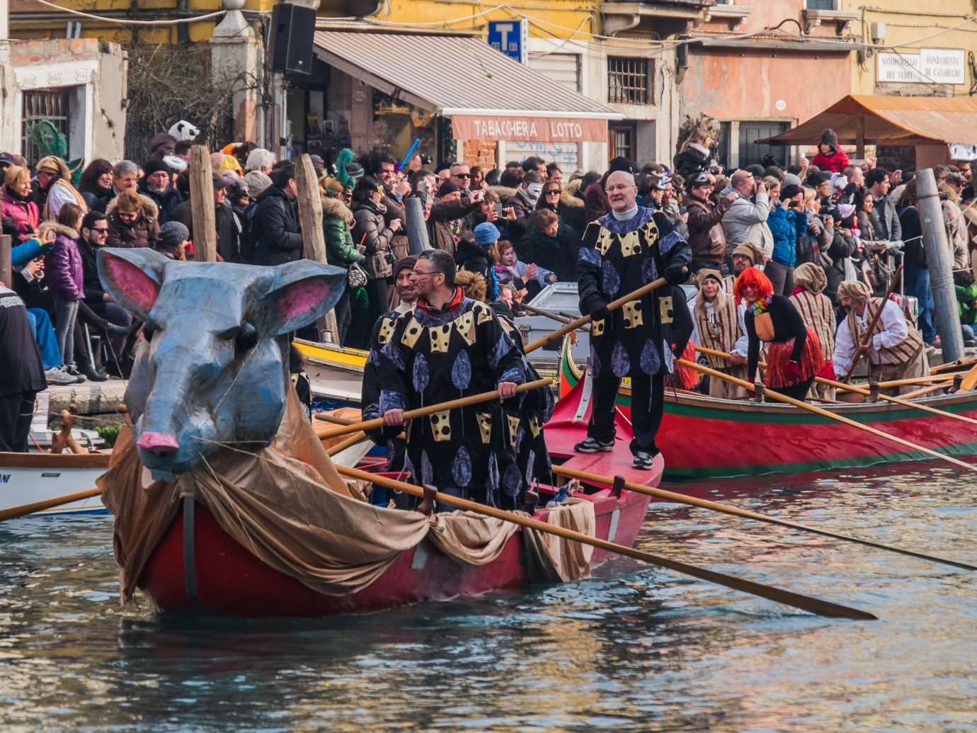 People dress up and row decorative boats in Venice