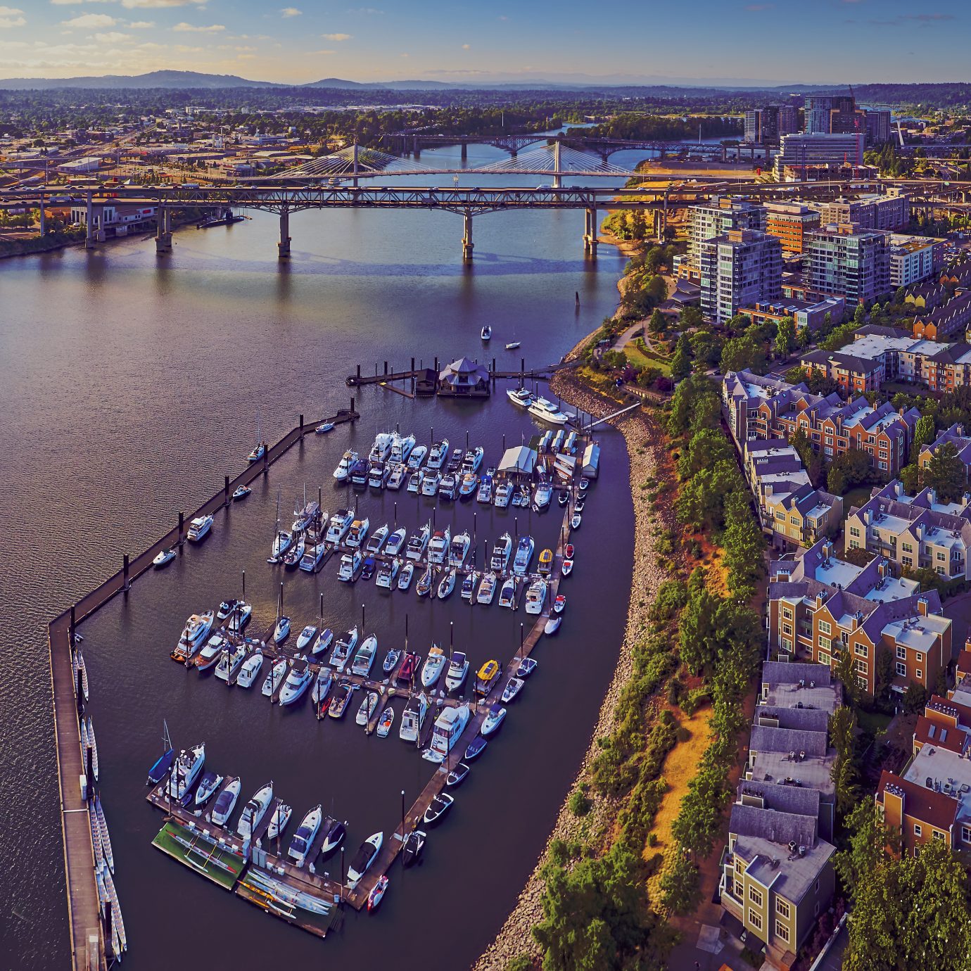 Aerial of Downtown Portland at Tom McCall Waterfront Park overlooking the Marina on early sunny morning with Tilikum Crossing Bridge in the distance