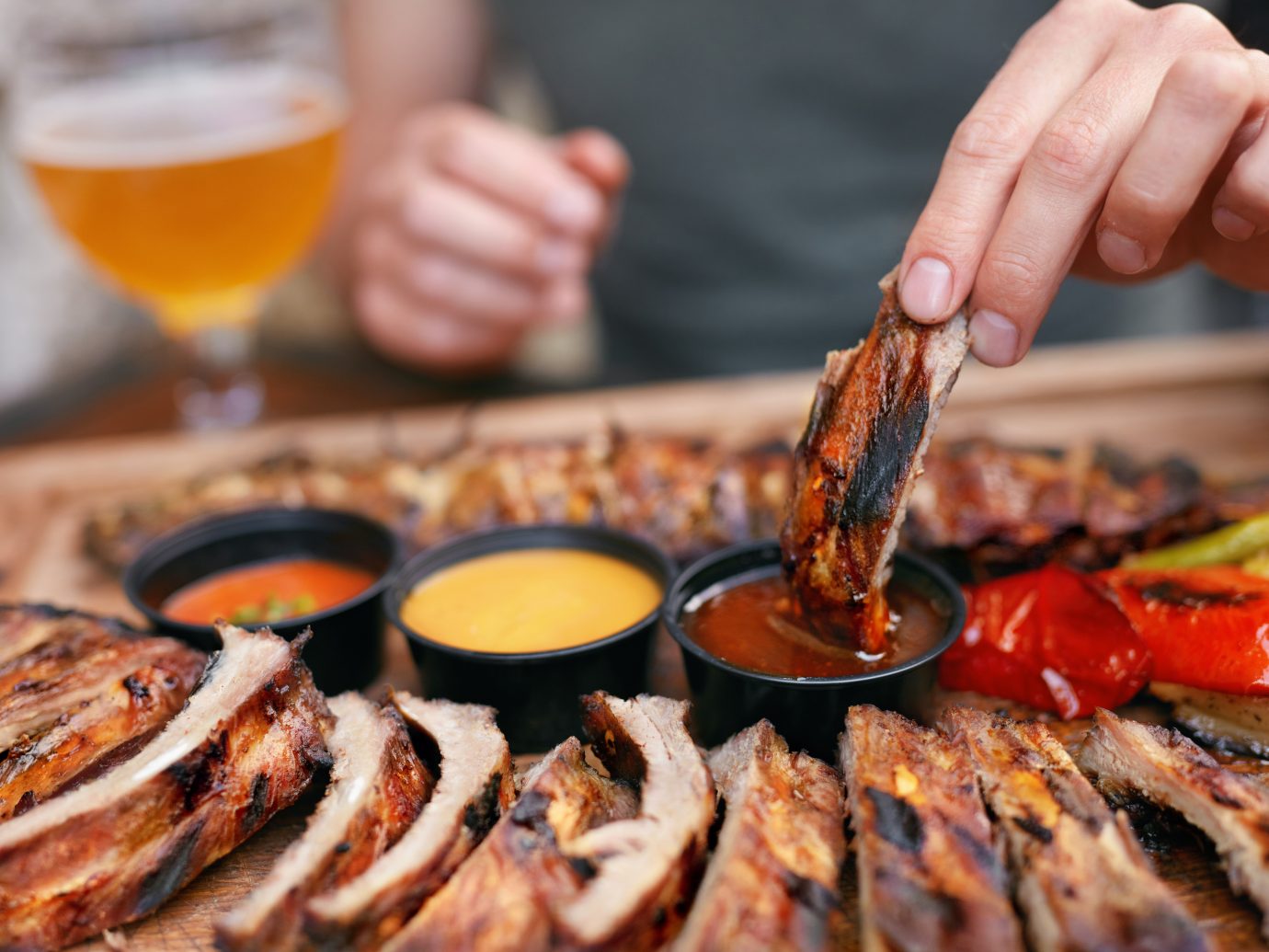 Barbecue Ribs With Sau?es Closeup. Man's Hand With Spareribs. High Resolution