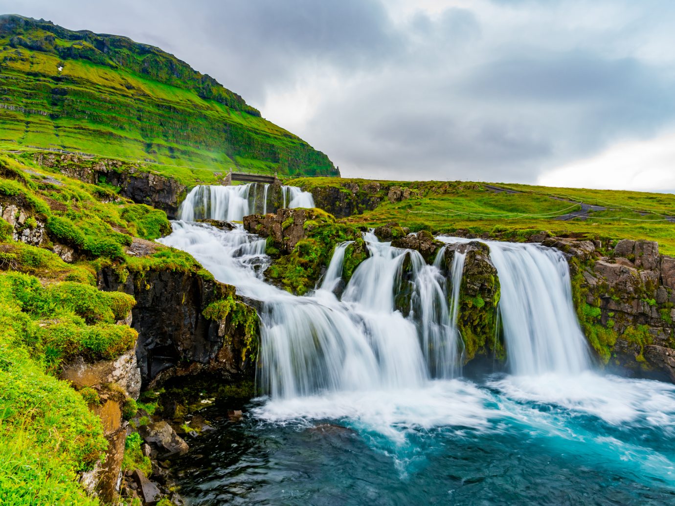 View of Kirkjufellsfoss Waterfalls at Kirkjufell Mountain in the summer rainy day at Grundarfjordur in West Iceland