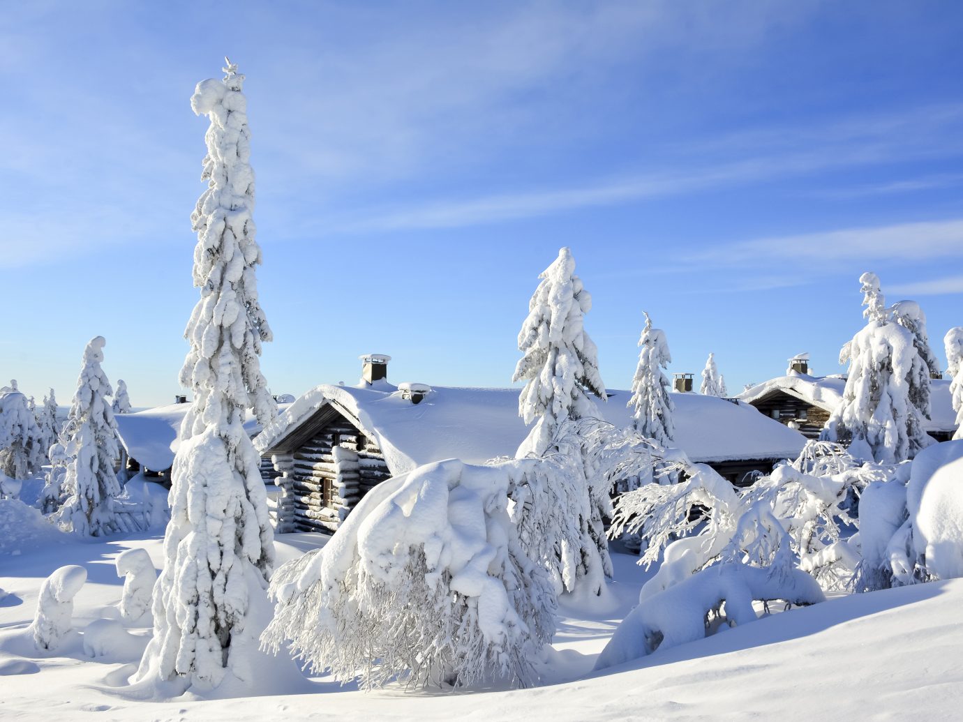 Cottages on snowy mountain on a sunny cold winter day on tourist resort in Lapland Finland.