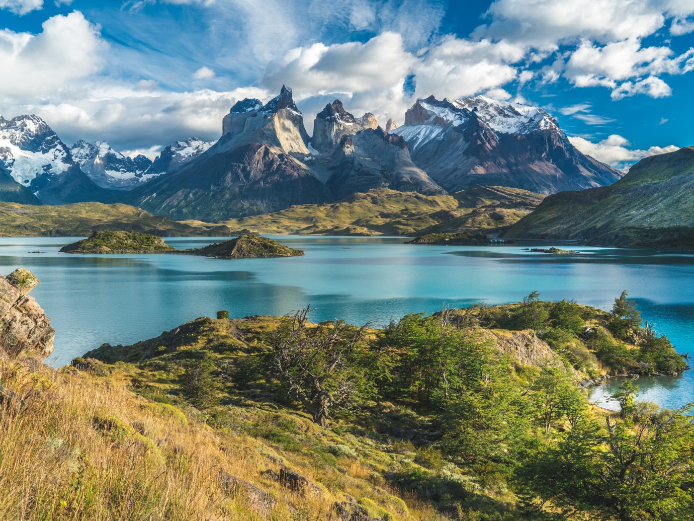Blue lake on a snowy mountains background and cloudy sky Torres del paine