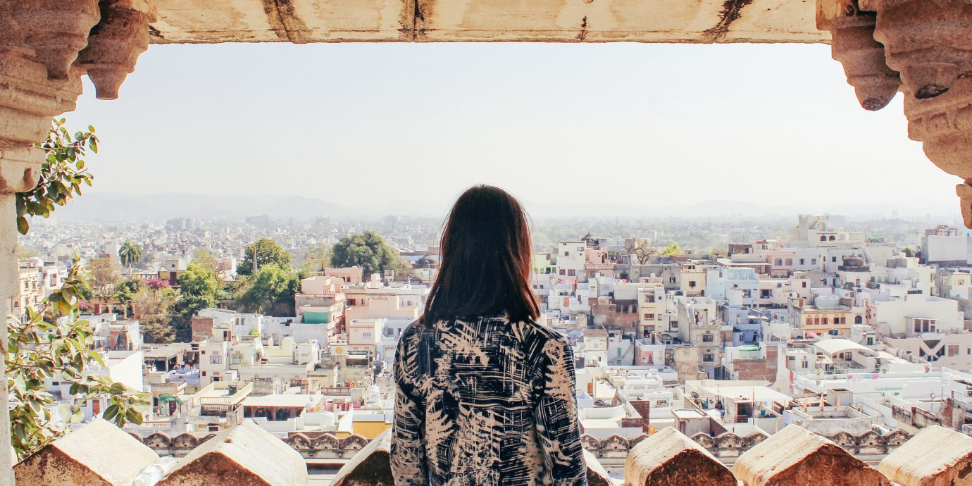 A young woman looks out over the city of Udaipur, Rajasthan, North India.