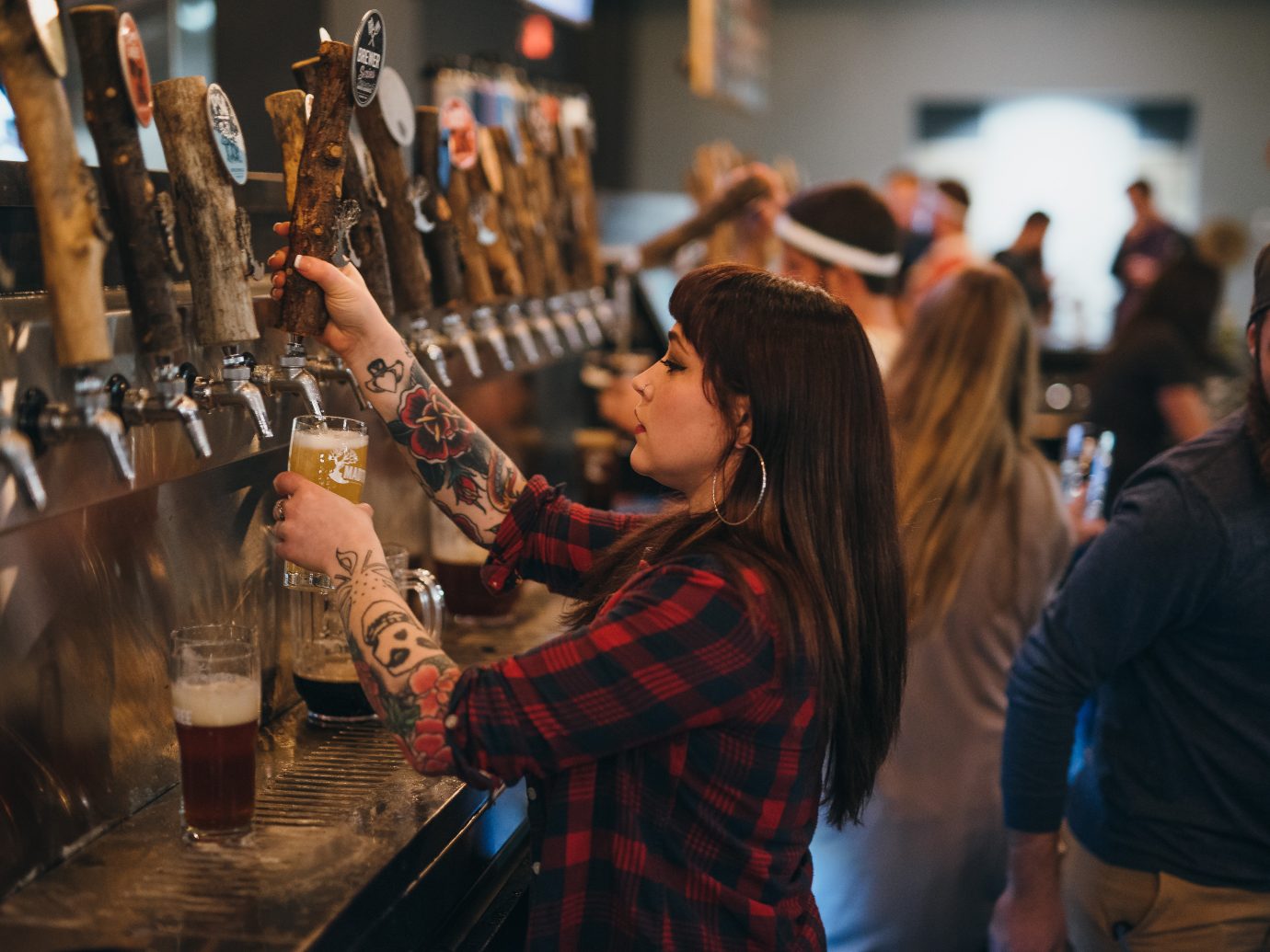 bartender pouring a beer from a tap at MadTree Brewing